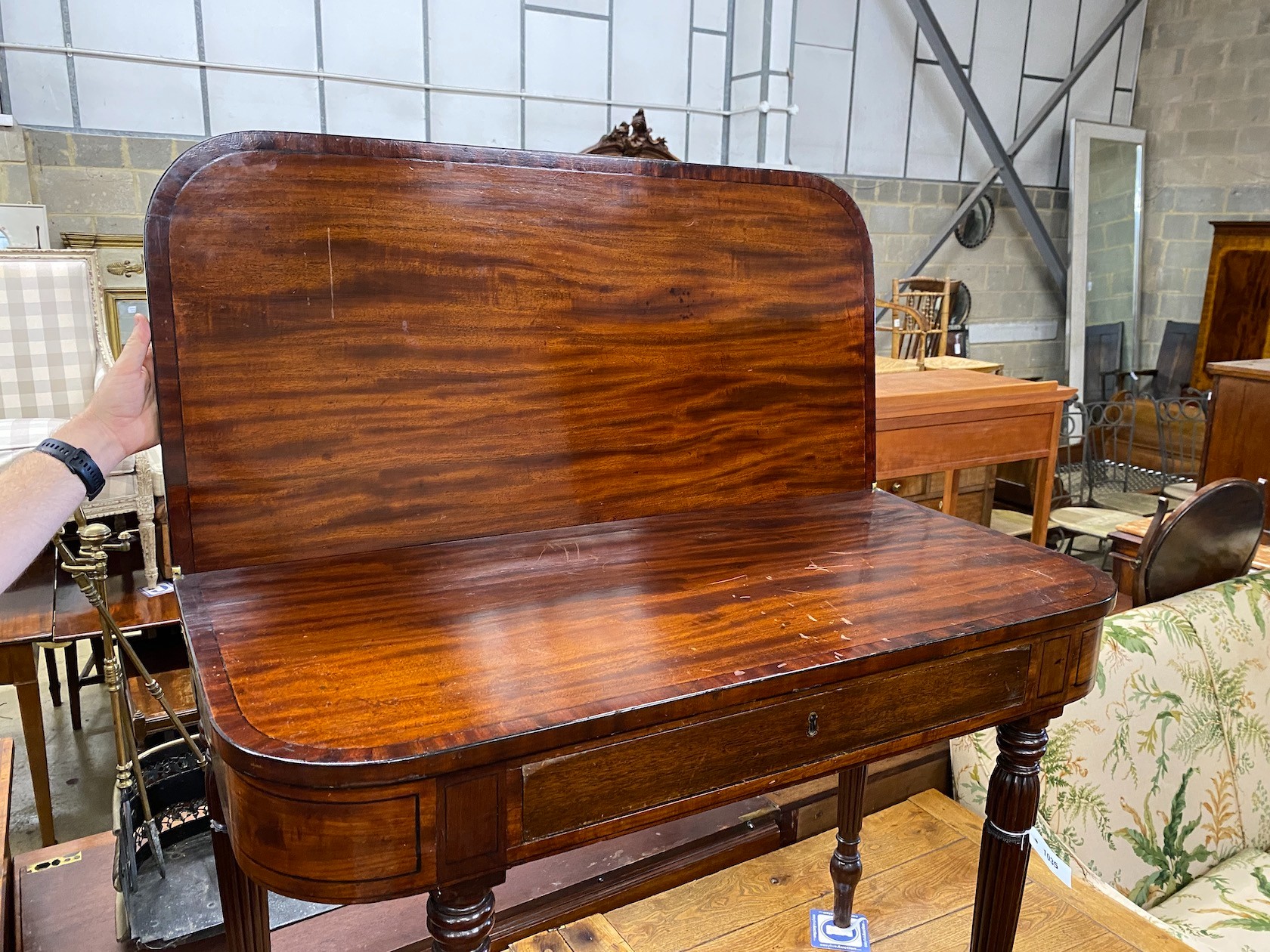 A George IV Gillows style ebony strung mahogany folding tea table on fluted legs width 99cm, depth 48cm, height 76cm.